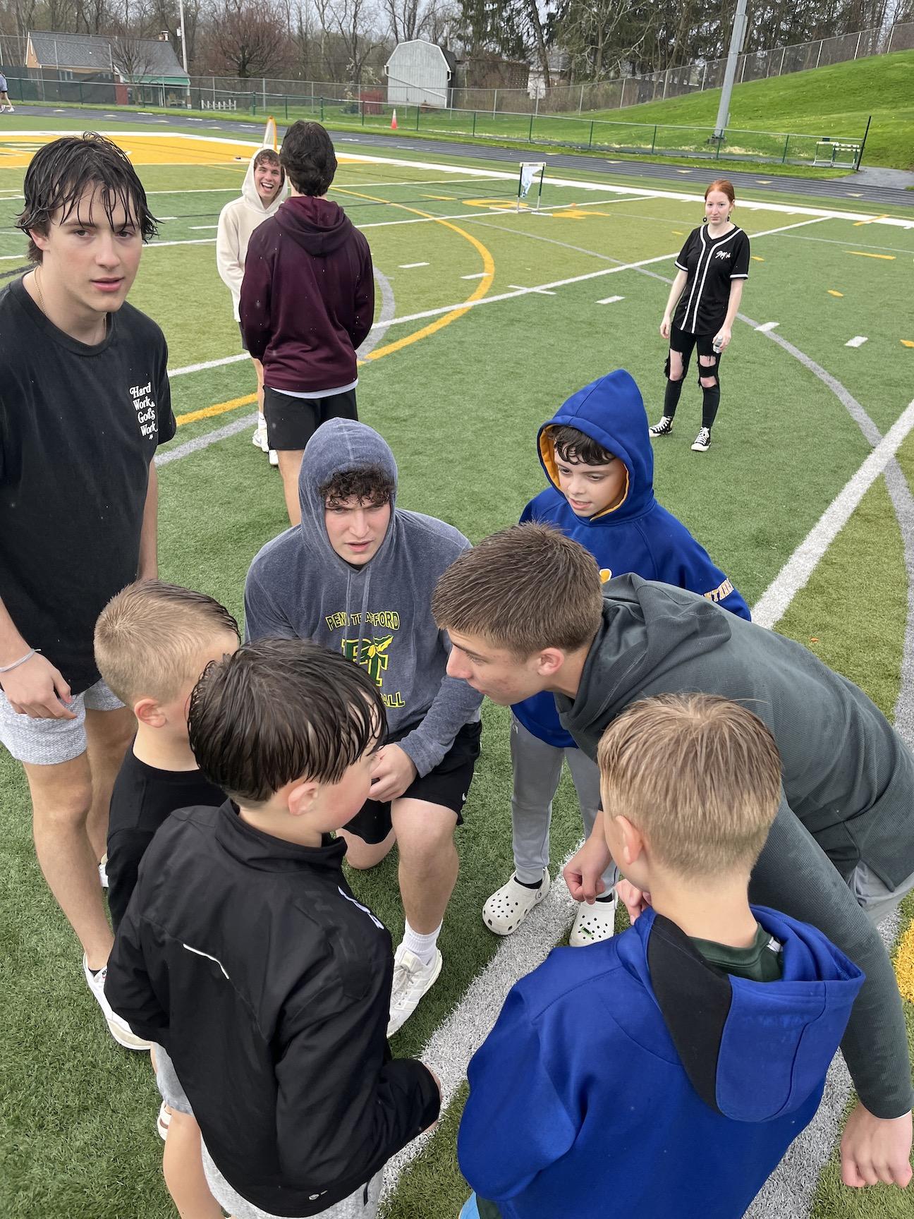 Junior Jack Weishaar (center) discusses a football play with his little brother Ryan Weishaar and friends Kellan Kiste, Nico Sterner, and Eli Hodge