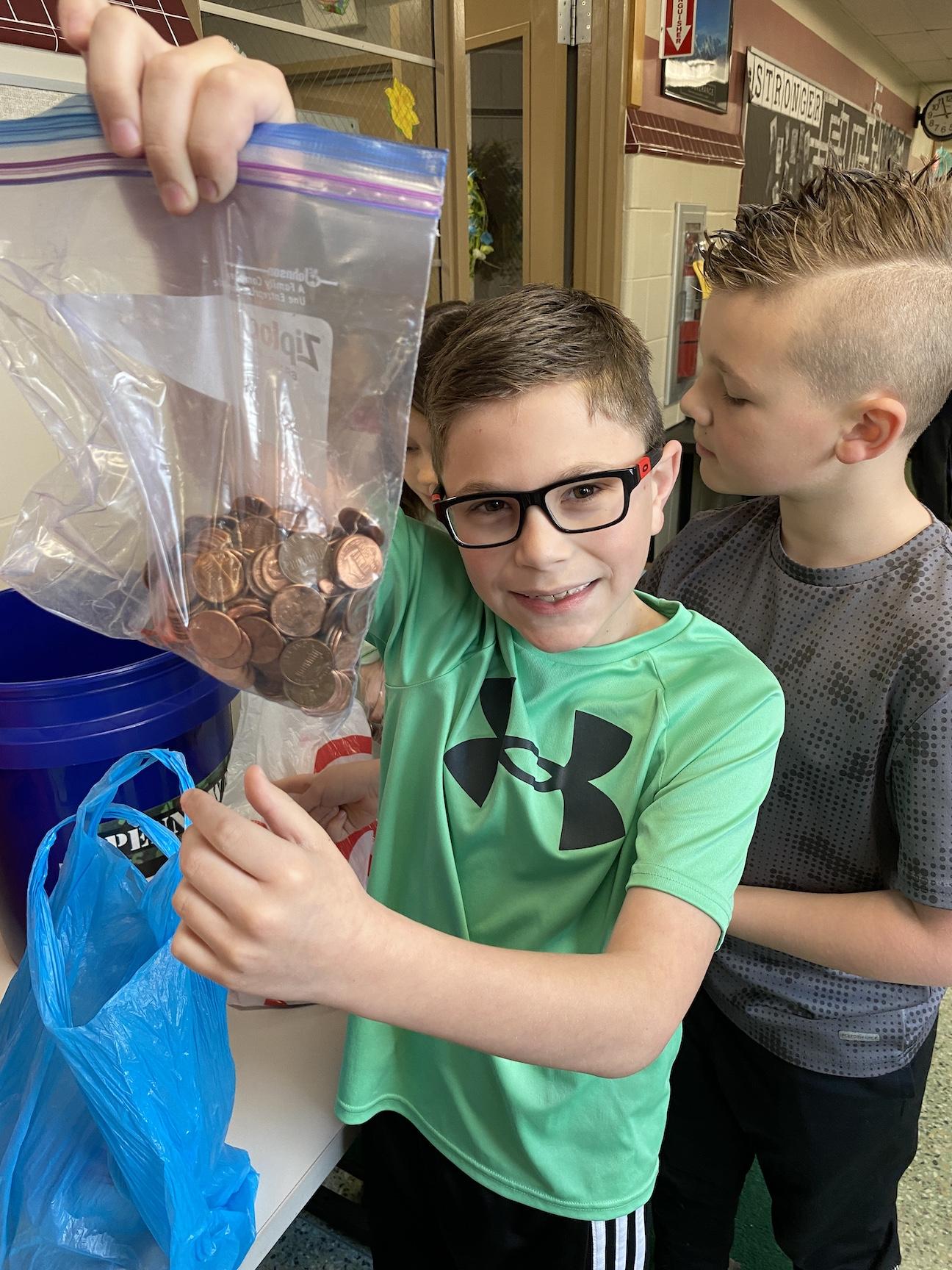 Johnny Dickun (grade 2) brought a bag full of pennies to donate to his classroom bucket
