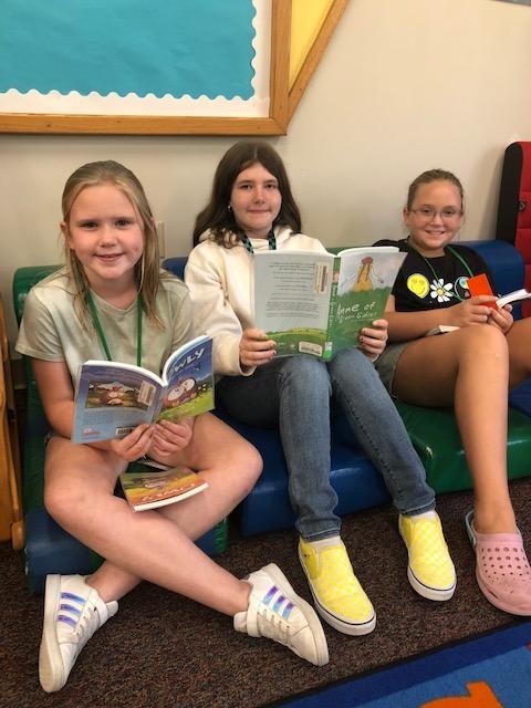 Fourth-graders Cecelia Grover, Jamisen Fitzroy, and Charlee Bussard each settle in with a new book