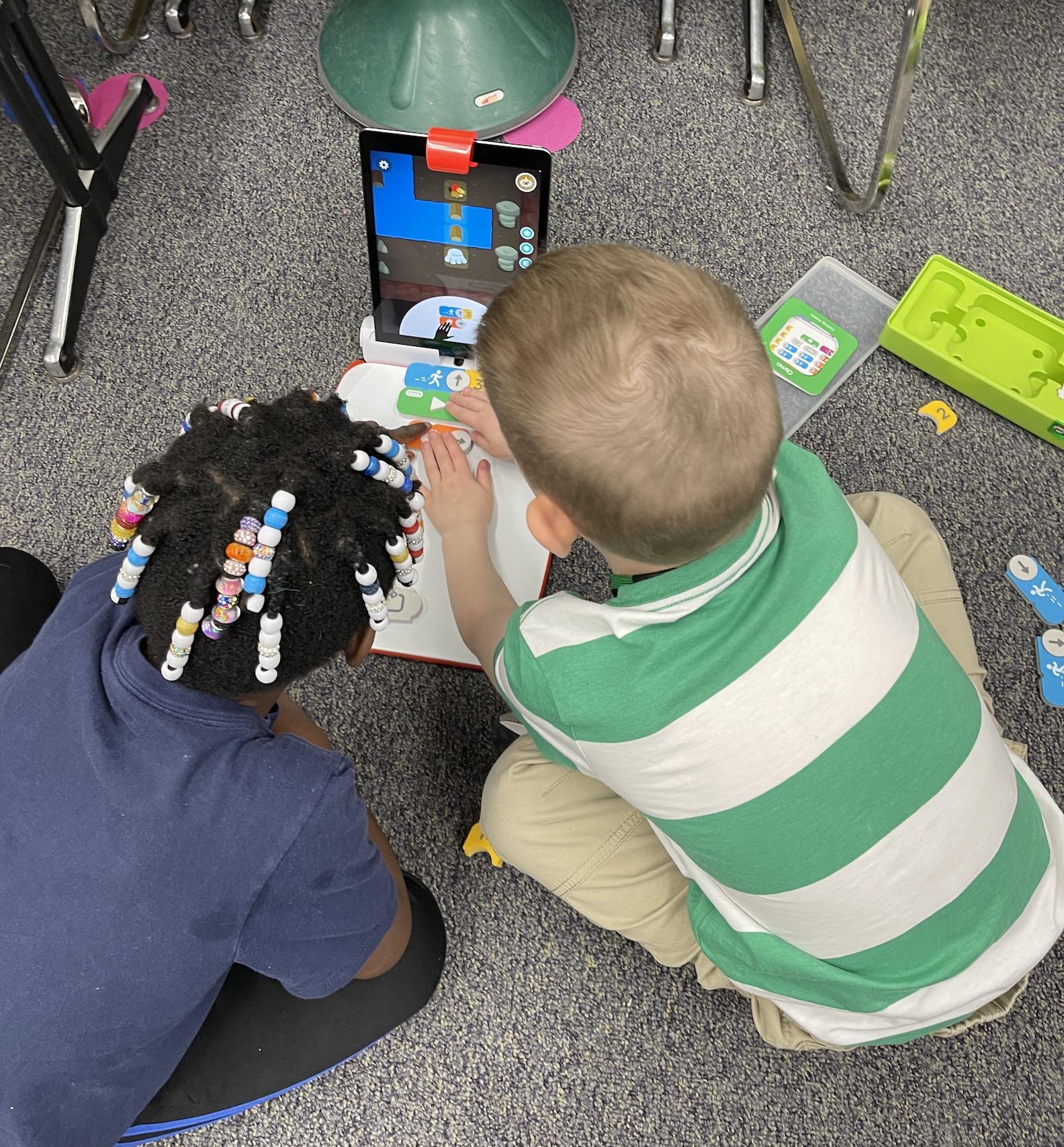 First-graders Michael Huber and Logan Fitzroy practice coding using Osmo tiles and a new ipad